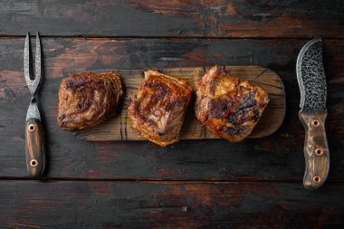 Pişmiş kısa kaburga seti, eski koyu ahşap masa arkaplanı, üst görünüm düz yatay, metin için kopyalama alanı ile