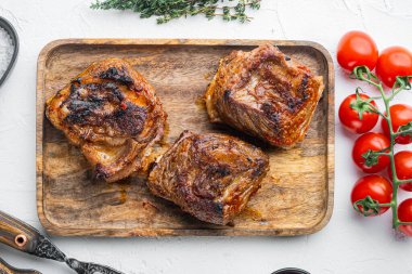 Lezzetli haşlanmış sığır kaburga seti, malzemelerle birlikte, beyaz taş arka planda, üst manzara düz.