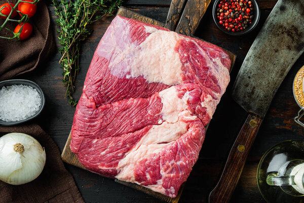 A whole piece of raw Beef Brisket set,with ingredients for smoking  making  barbecue, pastrami, cure, on old dark  wooden table background, top view flat lay