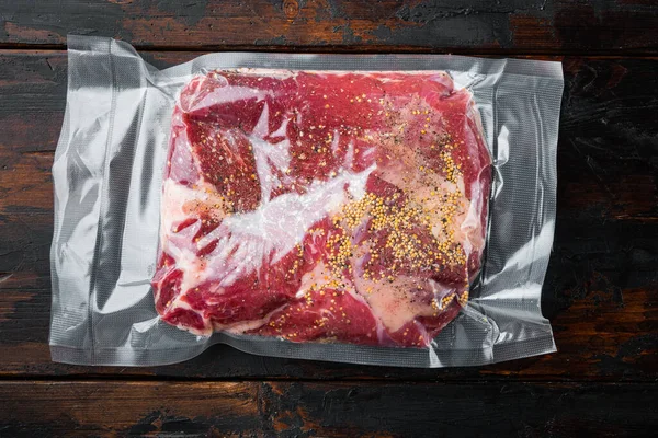 Raw brisket beef cut. Black Angus beef set,with ingredients for smoking  making  barbecue, pastrami, cure, vacuum sealed ready for sous vide cooking, on old dark  wooden table background, top view flat lay