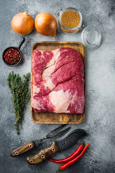 Raw brisket beef cut. Black Angus beef set,with ingredients for smoking  making  barbecue, pastrami, cure, on gray stone background, top view flat lay