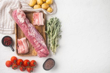 Çiğ domuz eti ve püre graten malzemeleri seti, ahşap tepside, beyaz taş zemin üzerinde, telif alanı ve metin için boşluk ile üst görünüm düz yatar