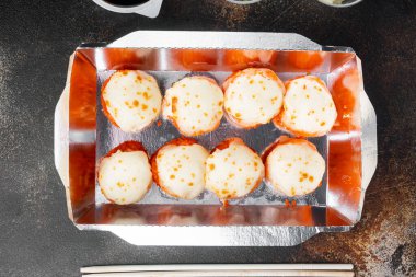 Konteynırlarda suşi rulolarını, Philadelphia rulolarını ve fırınlanmış karides rulolarını alıp götür. Eski, koyu kırsal arka planda, düz manzarada.