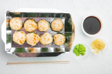 Farklı suşi çeşitleri ve rulo fro, somon ve ton balığı teslimat konsepti seti, beyaz taş arka planda, üst görünüm düz yatıyordu