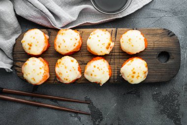 Wasabi ve zencefilli taze suşi ruloları, gri taş arka planda, üst manzara düz yatıyordu