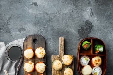 Wasabi ve zencefilli taze suşi ruloları, gri taş zemin üzerinde, üst görünüm düz, metin için telif alanı ve boşluk ile
