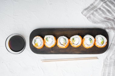 Suşi rulo somon ve ton balığının yemek çubukları beyaz taş zemin üzerinde, üst görünüm düz, kopyalanma alanı ve metin için boşluk