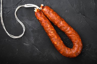İspanyol domuz sucuğu sosisleri siyah desenli arka planda.