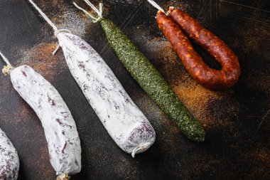 Koyu arkaplanda kurutulmuş sucuk ve fuet salam sosisi..