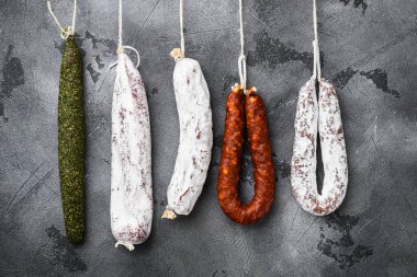 Gri dokulu arka planda pazardaki bir raftan İspanyol salamı.