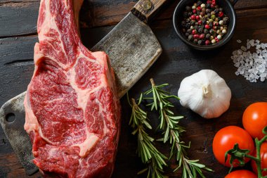 Et satırında taze tomahawk bifteği. Organik çiftlik mermer kaplama siyah angus bifteği. Koyu ahşap arka plan. Üst Manzara. Baharatlı, biberli, biberiyeli, tuzlu, sarımsaklı. Yakın mahsulü kapat.