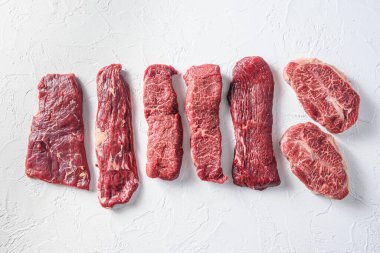 Denver set, top blade, tri tip biftek, Machete, bavette London barbekü mermer beyaz arka plan üst görünüm kavram alanı metin için.