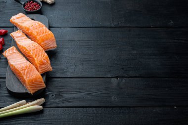 Pirzola için çiğ somon eti, siyah ahşap masa üzerinde metin için yer var.