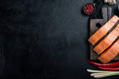 Somon otu ve baharatlı balık köftesi malzemesi, siyah desenli arka plan, düz metin için boşluk