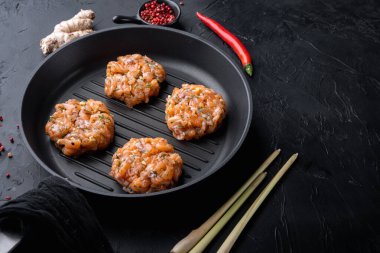 Siyah desenli arka planda hızlı Asya çiğ balık köfteleri.