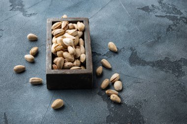 Kabuklu, tuzsuz şam fıstığı, gri arkaplanda mesaj için yer var.