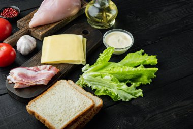 Lezzetli sandviç için taze malzeme, siyah ahşap masada.