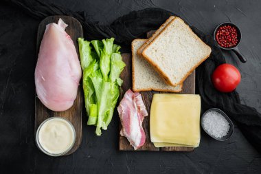 Kızarmış ekmek malzemesiyle nefis bir sandviç, siyah arka planda, üst tarafta.