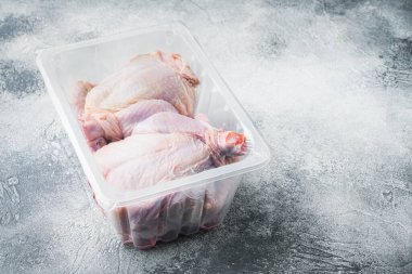 Gri arkaplanda tam pişmemiş tavuk eti paketi ve metin için kopyalama alanı