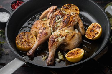 Kızarmış spatchcock poussin yemeği, eski ahşap masada.