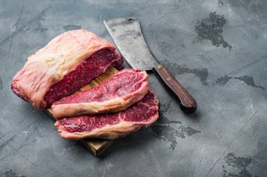 Kansas City çiğ organik biftek kesimi, gri arka planda, metin için kopya alanı ile