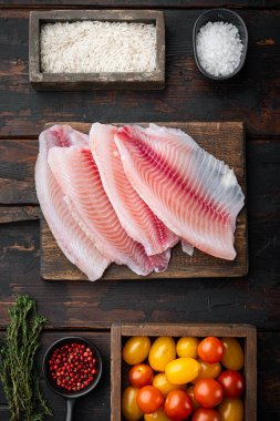 Beyaz balık filetosu, basmati pilavı ve kiraz domatesi malzemeleri, eski ahşap masa, üst manzara