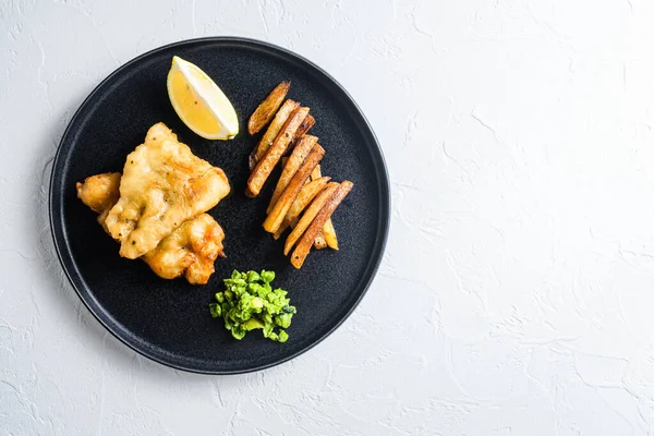 British  traditional food fish and chips with peas and a slice o