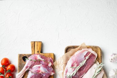 Serbest Çiftlik Ördeği et porsiyonları seti, otlar ve malzemelerle ahşap kesme tahtasında, beyaz taş zemin üzerinde, üst görünüm düz yerde, metin için metin alanı ve boşluk ile