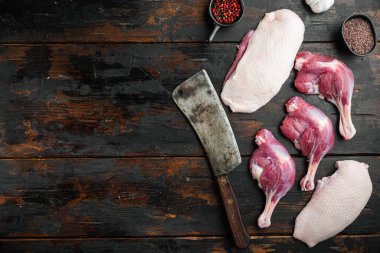 Eski kasap bıçağı ile ücretsiz ördek eti seti, eski koyu ahşap masa arka planı, üst görünüm düz, metin alanı ve telif alanı ile
