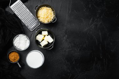 Siyah taş zemin, üst görünüm, düz yatay, metin için kopyalama alanı olan Bechamel sos malzemeleri seti