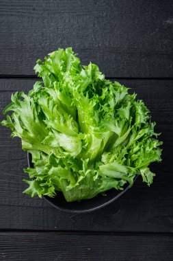 Yeşil taze marul taze yapraklar, siyah ahşap masa zemininde, üst manzara düz yatıyordu.