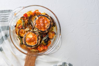 Portobello ve çedar peyniri, kiraz domatesleri ve beyaz arka planda cam kapta adaçayı pişirmek için malzemeler.