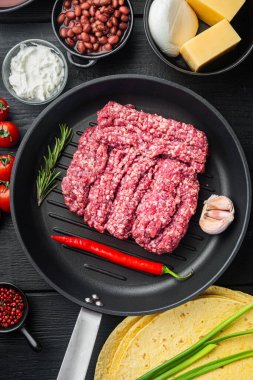 Quesadilla için tavuk: tortilla, mısır, tavuk, soğan, domates ve biber, peynir, siyah ahşap masa arkaplanı, üst görünüm düz