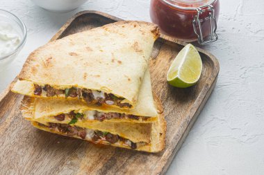 Beyaz arka planda, tavuklu mısır peynirli Meksika quesadilla 'sı.
