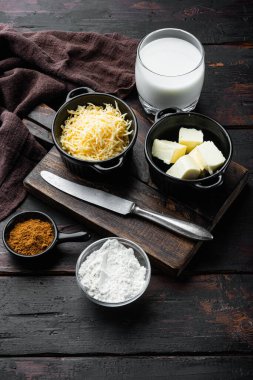 Eski siyah ahşap masa arkaplanının üzerinde bechamel peyniri beyaz sos seti hazırlama