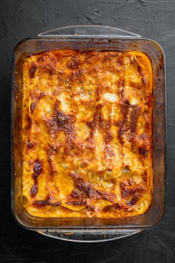 Bechamel peyniri ve Bolonez soslu klasik et lazanyası, fırın tepsisinde, siyah taş arka planda, üst tarafta, düz yerde.