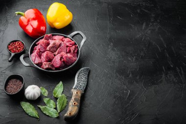 Çiğ et yahni için doğranır tatlı dolma biber, dökme demir tavada, siyah taş arka planda, metin için kopyalama alanı ile