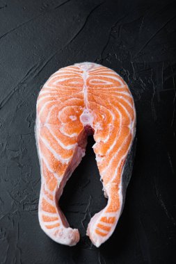 Siyah arka planda çiğ balıklı alabalık eti..