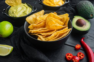 Nacho için farklı soslar, siyah ahşap arka planda.