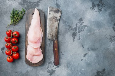 Çiğ tavuk filetosu, gri arkaplan üzerinde, üst görünüm düz metin için kopyalama alanı ile yatar