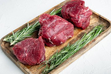 Beyaz taştan arka planda çiğ biftek fileto fileminyon seti.