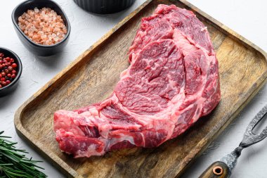 Çiğ biftek, biber, otlar, sarımsak, beyaz taştan arka planda mermer organik et setinden biberiye.