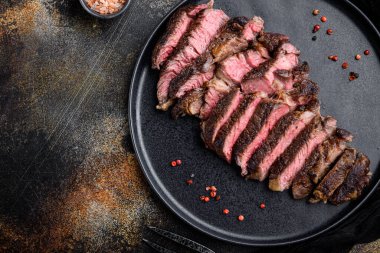 Orta pişmiş biftek seti, pirzola kesimi, tabakta, en üstte düz masa, metin için kopyalama alanı var.