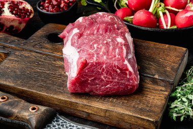 Çiğ biftek fileto fileto fileminyon seti, eski siyah ahşap masa arka planında.