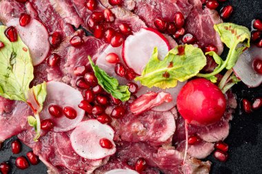 Şarap sirkesi setiyle taze carpaccio salatası, turp ve garnet tabakta, üst manzara düz.