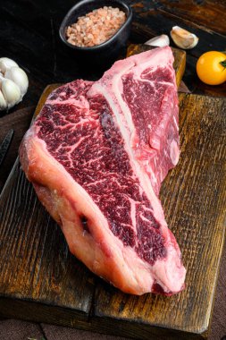 Gıda konsepti organik çiğ et seti, T kemik kesimi, ahşap kesim tahtası