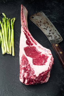 Barbekü Tomahawk mermer biftek seti ve siyah taş arka planda ızgara malzemeli eski kasap bıçağı.