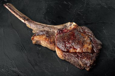 Tomahawk bifteği. Baharatlı ızgara. Siyah taş arka planda.