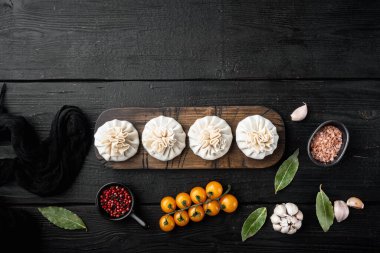 Biftek ve kuzu etli Khinkali köfteler, siyah ahşap masa arkaplanı, üst görünüm düz, metin alanı için kopyalama alanı