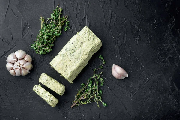 Portion of Herb Butter with Chives, Basil, Oregano, Parsley set, on black stone background, with copy space for text